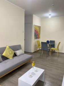 ein Wohnzimmer mit einem Sofa und einem Tisch in der Unterkunft Departamento de Estreno SEMREQ in Piura