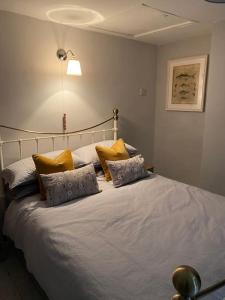 a bedroom with a large white bed with yellow pillows at Shardlow Cottage in Derby