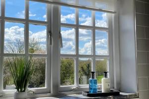 una ventana con dos botellas de vino en un mostrador en Shardlow Cottage en Derby