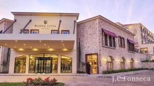 a man standing in front of a building at Hotel Buona Vitta in Gramado