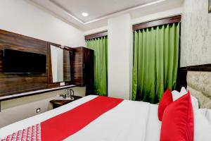 um quarto com uma cama com almofadas vermelhas e uma televisão em hotel adhunik palace em Keonjhargarh