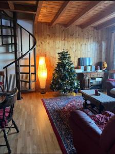 a living room with a christmas tree and a lamp at Appartamento Abetone Vacanze in Abetone