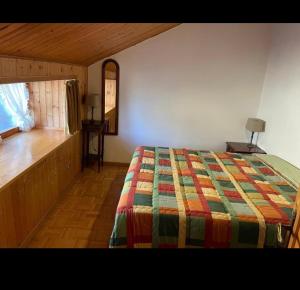 1 dormitorio con cama, espejo y ventana en Appartamento Abetone Vacanze, en Abetone