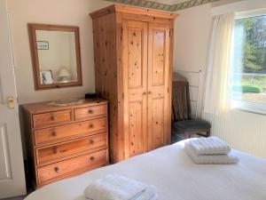 a bedroom with a dresser and a bed with a mirror at 1 Bed in Hawkshead and Tarn Hows LLH13 in Hawkshead