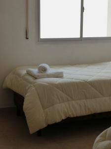 two beds in a room with towels on them at Habano Apart in Esquina
