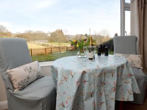 a table with wine bottles and glasses on it in front of a window at 1 Bed in Hawkshead Village LLH16 in Hawkshead