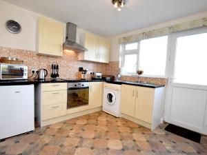 a kitchen with white cabinets and a washer and dryer at 1 Bed in Hawkshead Village LLH16 in Hawkshead