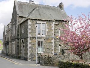 an old stone building with a flowering tree in front of it at 3 Bed in Hawkshead Village LLH21 in Hawkshead