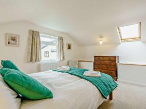 a bedroom with a large bed with green pillows at 5 Bed in Outgate and Tarn Hows LLH55 in Hawkshead