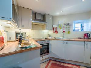 a kitchen with white cabinets and a plate of food on a counter at 2 Bed in Satterthwaite and Grizedale LLH56 in Grizedale