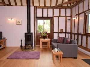 a living room with a couch and a wood stove at 1 Bed in Thaxted 51222 in Thaxted