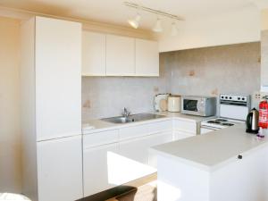 uma cozinha branca com armários brancos e um lavatório em 1 Bed in Outgate and Tarn Hows LLH50 em Hawkshead
