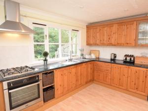 a kitchen with wooden cabinets and a stove top oven at 2 Bed in Sherborne 53673 in Chetnole