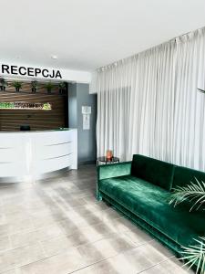 salon z zieloną kanapą i telewizorem w obiekcie Green Apartments Katowice Chorzów w mieście Chorzów