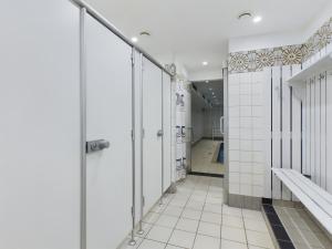 a bathroom with white tile walls and a walk in shower at Oland Whg 23 Küstensegler in Wyk auf Föhr