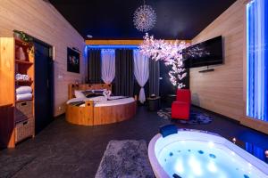 a bedroom with a tub and a bed and a chandelier at Rien Que Nous 