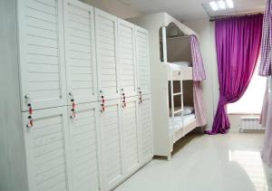 MY HOSTEL في بيشكيك: غرفة نوم ذات أبواب بيضاء وستائر أرجوانية