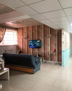 MY HOSTEL في بيشكيك: غرفة معيشة مع أريكة وتلفزيون