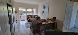 莫塞尔湾The Barefoot Cottage的客厅里有一张沙发和一张桌子。