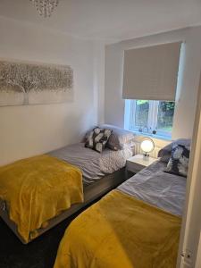 a bedroom with two beds and a window at Betjiman Retreat Relaxtion Awaits in Gateshead