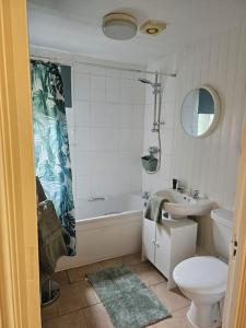a bathroom with a sink and a tub and a toilet at Betjiman Retreat Relaxtion Awaits in Gateshead