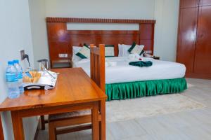 a hotel room with a bed and a table with a table sidx sidx at Kerama Silent Lodge in Arusha