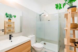 uma casa de banho com um WC e uma cabina de duche em vidro. em Guest Inn 1 Boutique House em Lisboa