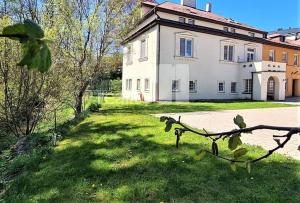 a large white building with a grass yard in front of it at APARTMÁN U MAXÍKŮ in Černý Dŭl