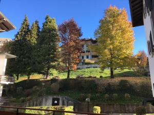 un edificio en una colina con árboles en el fondo en Grazioso appartamento, en Cassina Valsassina