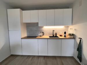 een keuken met witte kasten en een spoelbak bij Casa Verde in Benitachell
