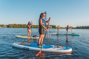 un grupo de personas en tablas de paddle en el agua en Parc de l'Île Melville 1 - Maison flottante, en Shawinigan