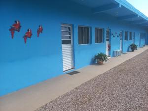 a blue building with superheroes painted on it at Pousada Lagoinha in Ubatuba