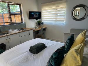 a bedroom with a bed with a towel on it at Private Cottage on Alamein in Cape Town