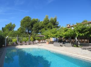 - une piscine avec des chaises, une table et des arbres dans l'établissement Domaine de Claude, à La Cadière-dʼAzur