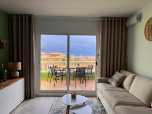 een woonkamer met een bank, een tafel en stoelen bij Casa Verde in Benitachell