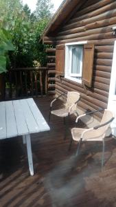 - une table de pique-nique et 2 chaises sur une terrasse en bois dans l'établissement pewmamapu2, à Potrerillos