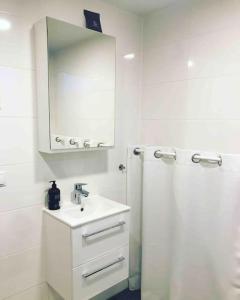 a white bathroom with a sink and a shower at Eget hus i Örgryte. Göteborgs bästa läge! in Gothenburg