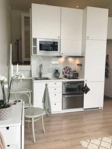 uma cozinha com armários brancos, um lavatório e uma mesa em Eget hus i Örgryte. Göteborgs bästa läge! em Gotemburgo