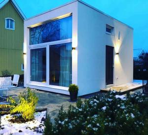 uma casa branca com uma grande porta de vidro deslizante em Eget hus i Örgryte. Göteborgs bästa läge! em Gotemburgo
