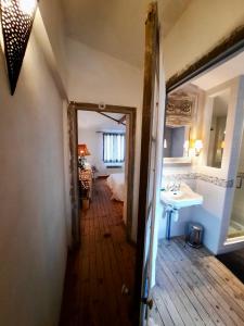 einen Flur mit Bad und Waschbecken in einem Zimmer in der Unterkunft Pierres et Jardins in Senlis