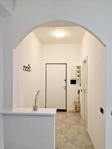 a white kitchen with an archway leading to a door at FUORI dal COMUNE in Corsico