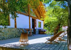 two wooden benches sitting in front of a building at Adobe Ecohostel in Villa Meliquina