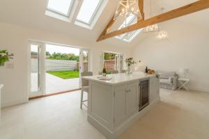 a kitchen with a white island in a room with windows at Limestone House in Burnham Market