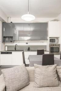 une cuisine avec un canapé et une table dans l'établissement Grazioso appartamento in Bicocca con AC e Wi-fi, à Milan