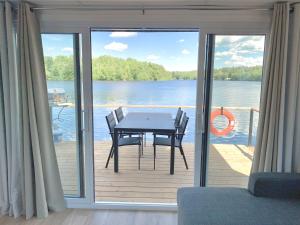 a table and chairs on a deck with a view of the water at Parc de l'Île Melville 1 - Maison flottante in Shawinigan