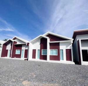 una fila di case con rosso e bianco di BM Beach Resort Satun บีเอ็มบีชรีสอร์ท a Ban Pak Ba Ra