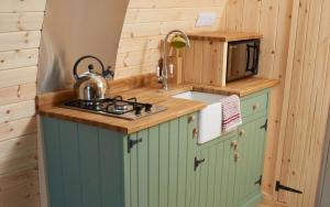 a small kitchen with a stove and a microwave at Mountain Edge Resort Mega pod 1 with Hot Tub in Church Stretton