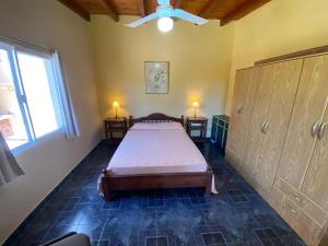 1 dormitorio con 1 cama, 2 mesas y una ventana en Complejo "NONI" 200 mts del mar, barrio tranquilo, en Las Grutas