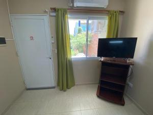 Una pequeña habitación con televisión y una ventana. en Complejo "NONI" 200 mts del mar, barrio tranquilo, en Las Grutas