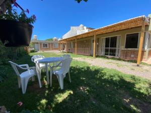 una mesa y sillas en el patio de una casa en Complejo "NONI" 200 mts del mar, barrio tranquilo, en Las Grutas